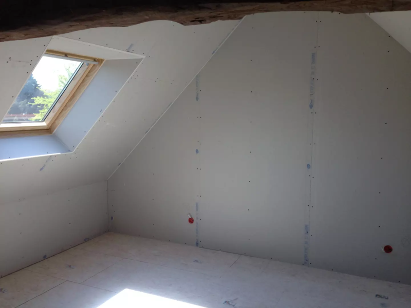 Combles en placo sur murs et sous-pente, velux bois, boîtiers électriques rouges, sol OSB