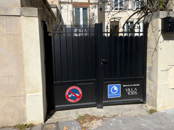 Portail battant alu noir festonné entre piliers pierre, panneaux Dépose minute et Villa Robs