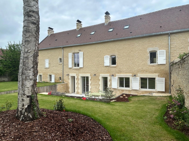 Demeure pierre : volets blancs persiennés, baies vitrées et terrasse pierre
