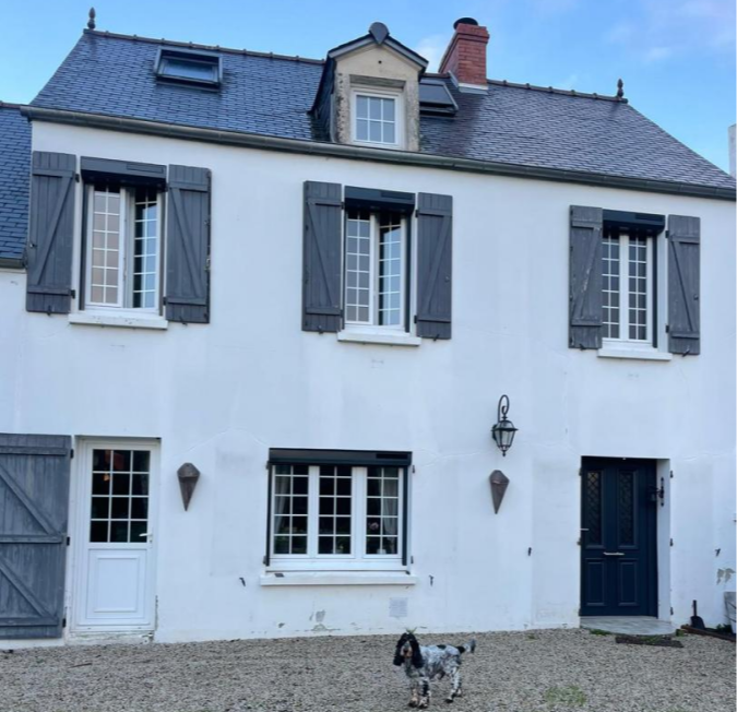 Maison blanche ardoise, fenêtres à croisillons, volets bois gris et coffres roulants, gravier