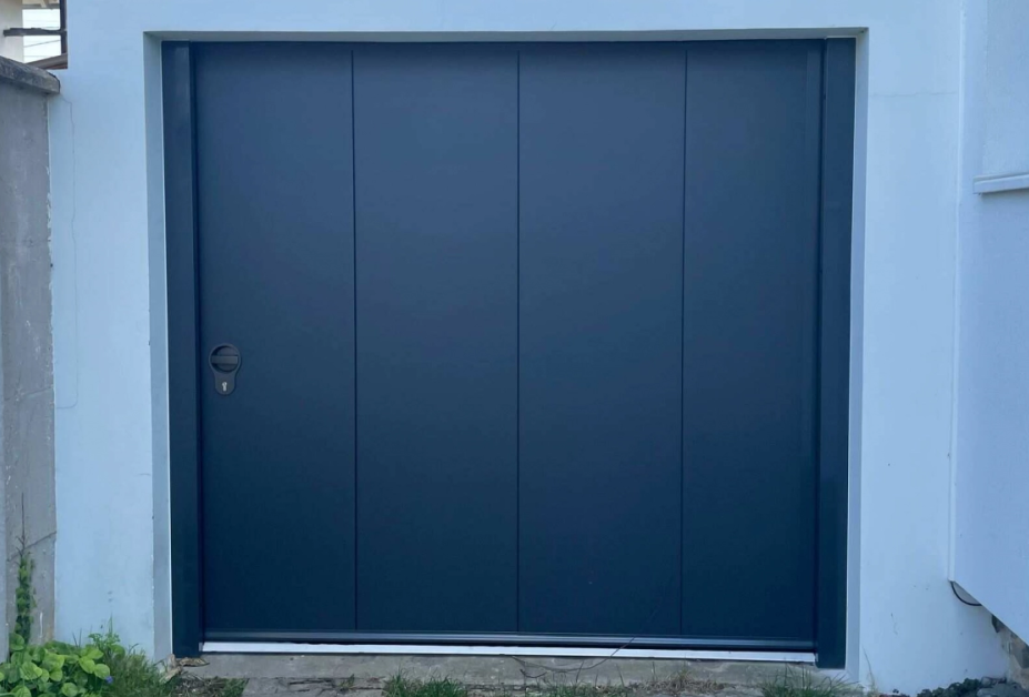 Porte garage latérale anthracite, quatre panneaux lisses, poignée noire, mur blanc
